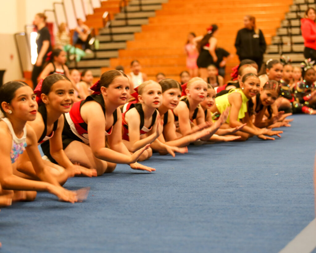Home Group of X-Out Competition Participants Sitting on Sidelines