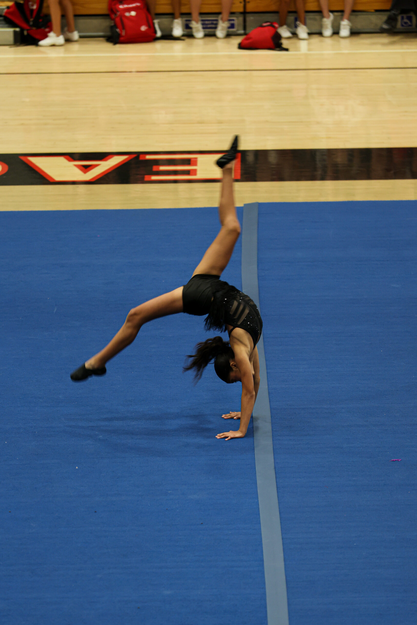 Home Student performing acrobatic routine at X-Out Cheer Competition